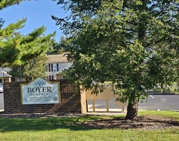Hughesville apartment for rent - a tree in front of a building with a sign