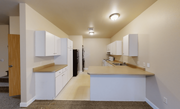 Oshkosh townhouse for rent - A kitchen with white cabinets and a black refrigerator.