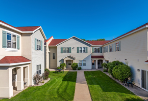 Oshkosh townhouse for rent - A row of houses with a green lawn in front.