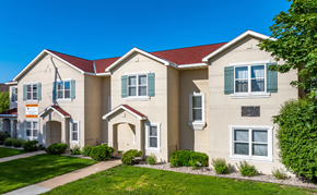 Oshkosh townhouse for rent - A beige house with green shutters and a red roof.