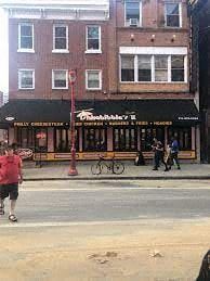Philadelphia apartment for rent - a man walking down a street in front of a restaurant