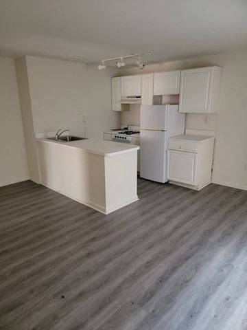 Philadelphia apartment for rent - an empty kitchen with white cabinets and a white refrigerator