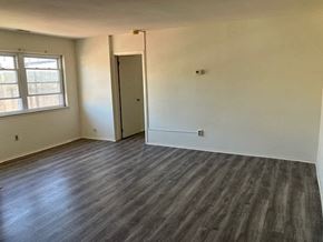 Philadelphia apartment for rent - an empty living room with wooden floors and a window