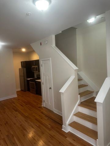 Philadelphia apartment for rent - a renovated living room with stairs and a door to a kitchen