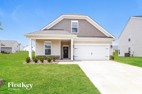 Greenville house for rent - a beige house with a white garage door