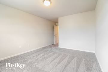 Greenville house for rent - a spacious living room with carpet and white walls