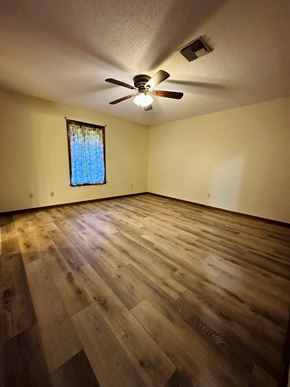 Lafeyette house for rent - an empty living room with wooden floors and a ceiling fan