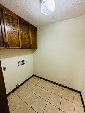 Lafeyette house for rent - a room with a tile floor and white walls and wooden cabinets