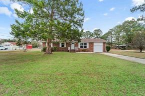 Jacksonville house for rent - the front of a brick house with a lawn and a tree