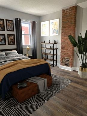 Baltimore house for rent - a bedroom with a bed and a brick fireplace
