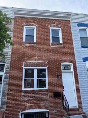Baltimore house for rent - a brick building with a white door and windows