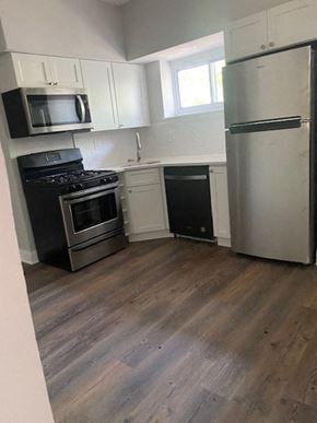 Baltimore house for rent - a kitchen with stainless steel appliances and white cabinets
