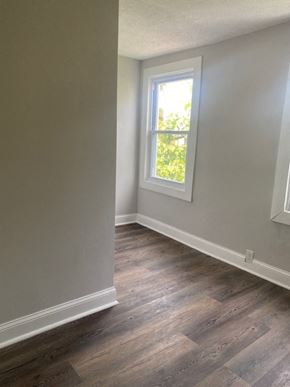 Baltimore house for rent - an empty room with wooden floors and a window