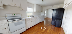 Whiteville house for rent - a kitchen with white appliances and a black refrigerator