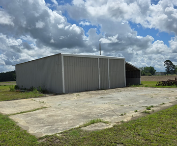 Chadbourn apartment for rent - A large grey building with a metal roof and a small antenna on top.