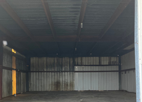 Chadbourn apartment for rent - A large, empty warehouse with a corrugated metal wall and a wooden ceiling.