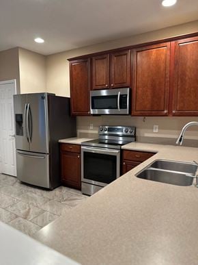 Jacksonville house for rent - a kitchen with stainless steel appliances and wooden cabinets