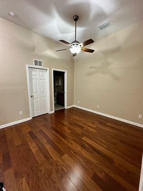 Jacksonville house for rent - a living room with wood floors and a ceiling fan