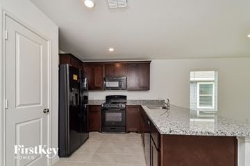 Princeton house for rent - a kitchen with a granite counter top and a black refrigerator
