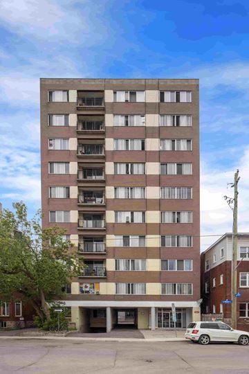 Ottawa apartment for rent - A tall building with a car parked in front of it.