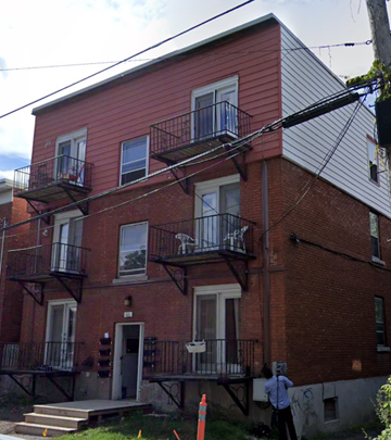 Ottawa apartment for rent - a red brick building with a man standing outside of it