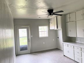 Littlefield house for rent - a kitchen with white cabinets and a ceiling fan