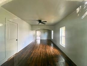 Littlefield house for rent - an empty living room with wood floors and a ceiling fan