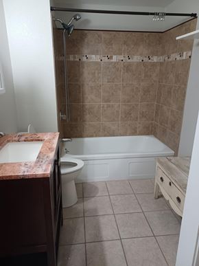 Soap Lake house for rent - A bathroom with a tub, toilet, and sink.