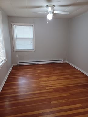 Soap Lake house for rent - A room with wooden floors and a ceiling fan.