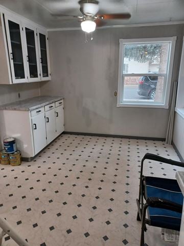 Soap Lake house for rent - A kitchen with white cabinets and a window with a view of a street.