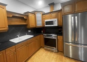 Edmonton apartment for rent - a kitchen with stainless steel appliances and wooden cabinets