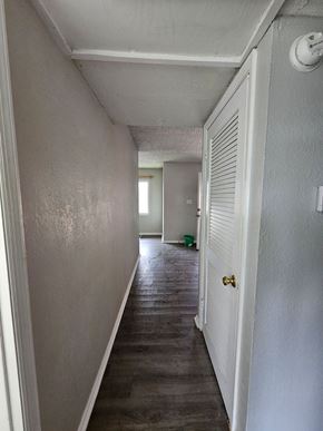 Hughes Springs house for rent - A long white hallway with a door on the right.