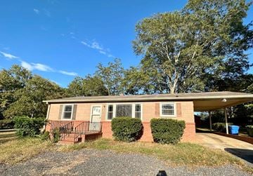 Mauldin house for rent - a small brick house with a front porch and a tree