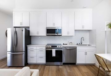 Ventura apartment for rent - A modern kitchen with white cabinets and stainless steel appliances.