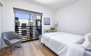 Ventura apartment for rent - A bedroom with a large bed, a chair, and a window with blinds.