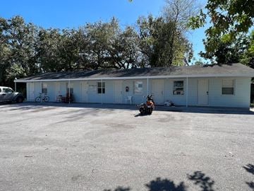 Palmetto apartment for rent - a white building with a motorcycle parked in front of it