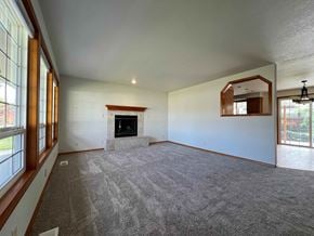 Longview house for rent - A spacious living room with a fireplace and large windows.