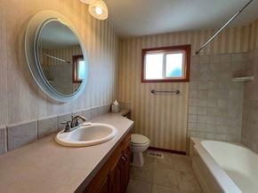 Longview house for rent - A bathroom with a sink, toilet, and bathtub.