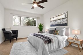 Brentwood apartment for rent - A bedroom with a large bed, a chair, and a ceiling fan.
