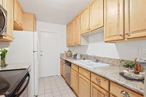 Brentwood apartment for rent - A kitchen with wooden cabinets and a white refrigerator.