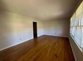 Fayetteville house for rent - an empty living room with wood flooring and a window