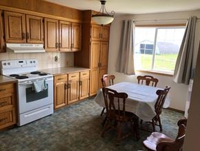 Prince Albert house for rent - A kitchen with a stove, table and chairs.