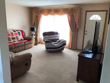 Prince Albert house for rent - A living room with a striped chair in the middle.