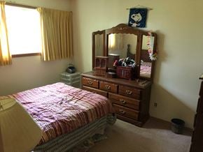 Prince Albert house for rent - A bedroom with a bed, dresser, and mirror.