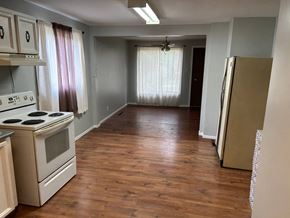 Prince Albert house for rent - a kitchen and a hallway with a stove and a refrigerator