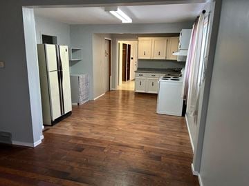 Prince Albert house for rent - a kitchen with a hard wood floor and a refrigerator