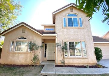 Merced house for rent - a beige house with a front door and windows