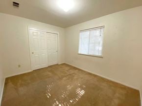 Merced house for rent - an empty living room with a white door and a window