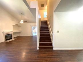 Merced house for rent - a view of a living room with a staircase and a fireplace