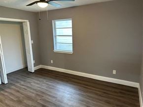 Houston house for rent - an empty living room with wood floors and a window
